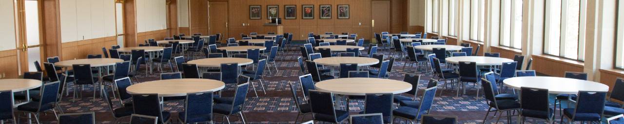 An interior view of the Loosemore Forum in the L.William Seidman Center staged with round tables and chairs, but otherwise empty